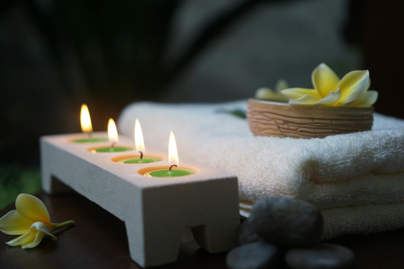 Bougies de spa allumées et fleur de frangipanier dans une ambiance apaisante à la Maison Solène